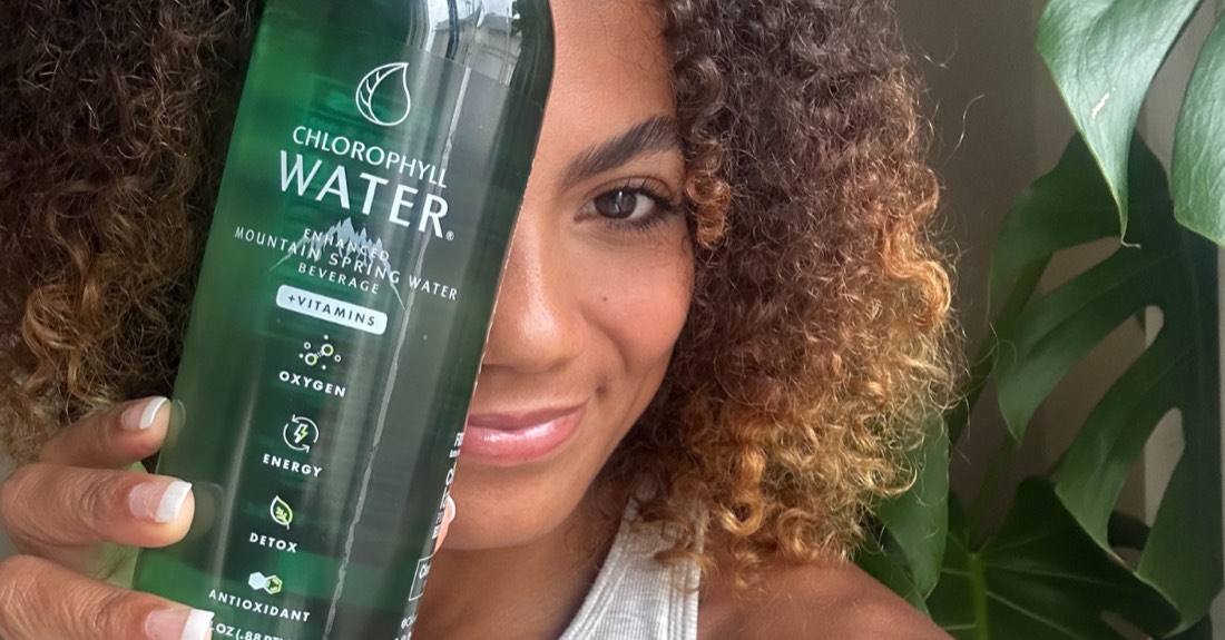 A woman holding a bottle of Chlorophyll Water in front of her face