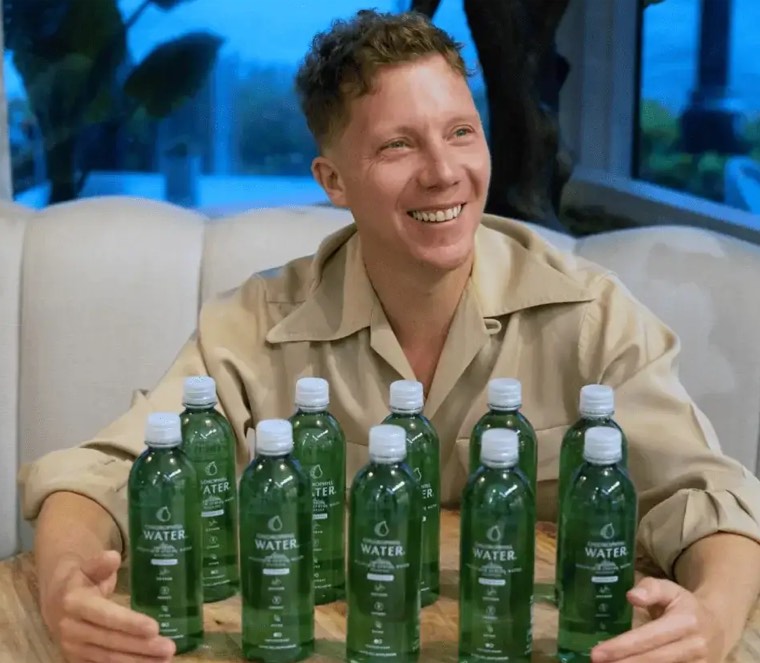 Matt Levine, founder of Chlorophyll Water, behind a row of bottles