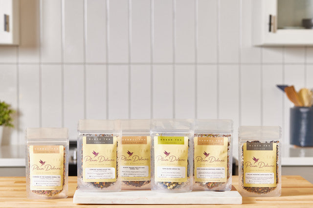 A row of Plum Deluxe tea pouches on a counter
