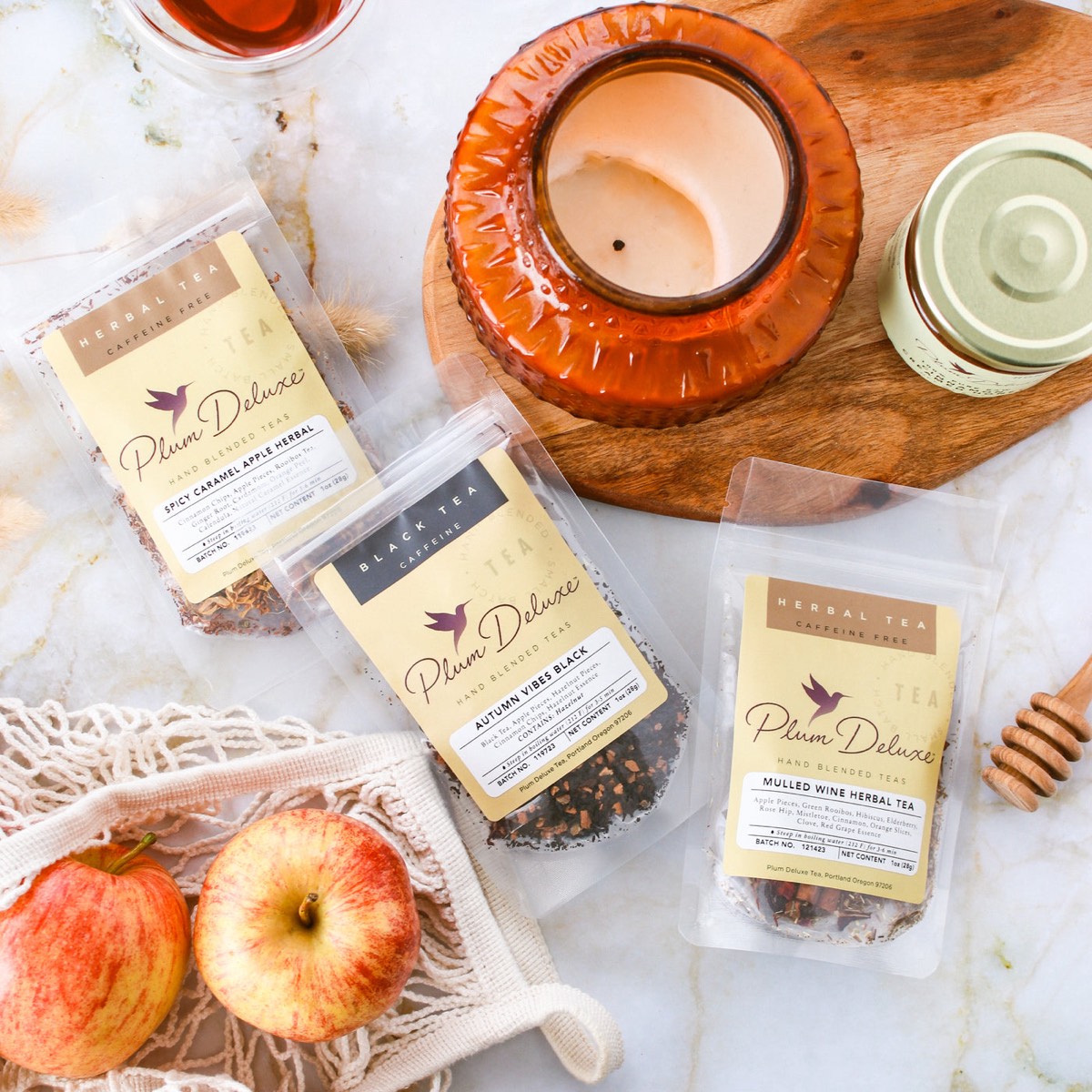 Plum Deluxe tea pouches with apples, a candle and honey